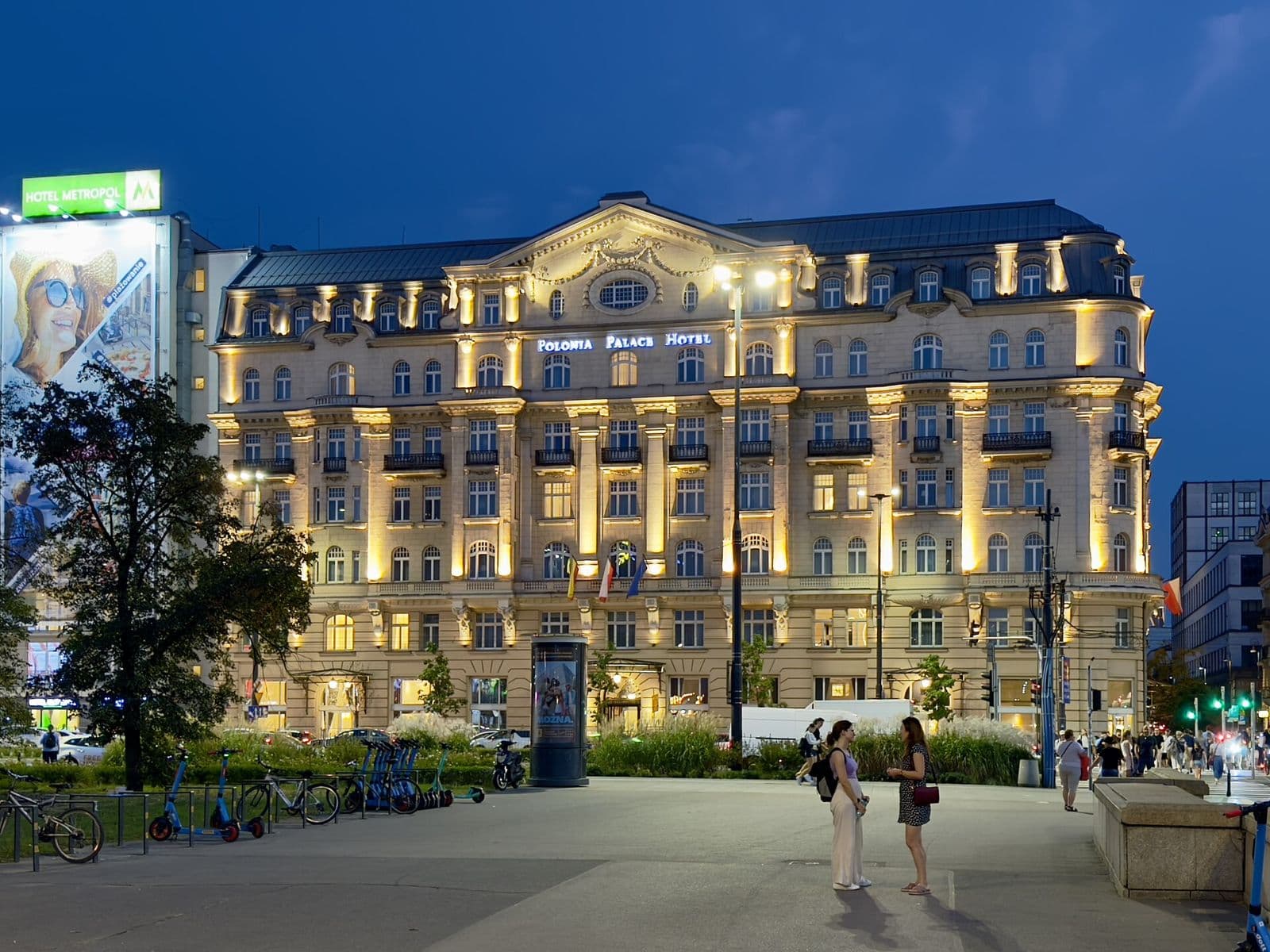 The lit facade of Polonia Palace Hotel on Aleje Jerozolimskie at dusk