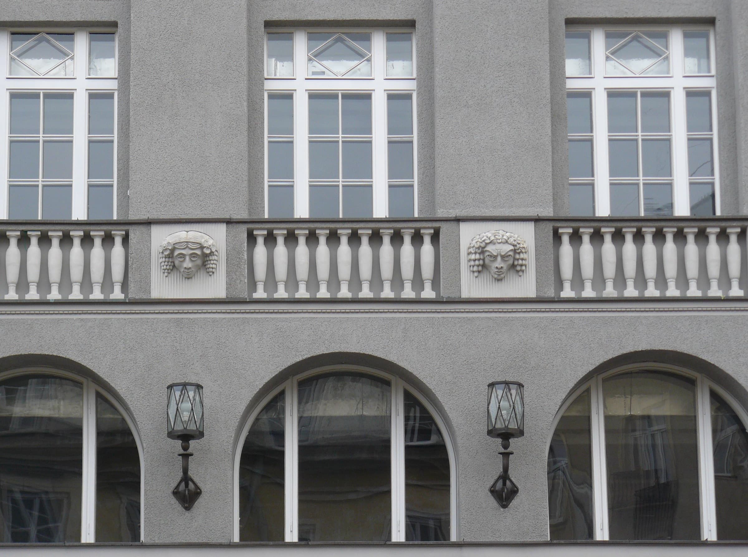 Arched ground-floor windows and a balustrade on the facade of Dom Towarowy Bracia Jabłkowscy