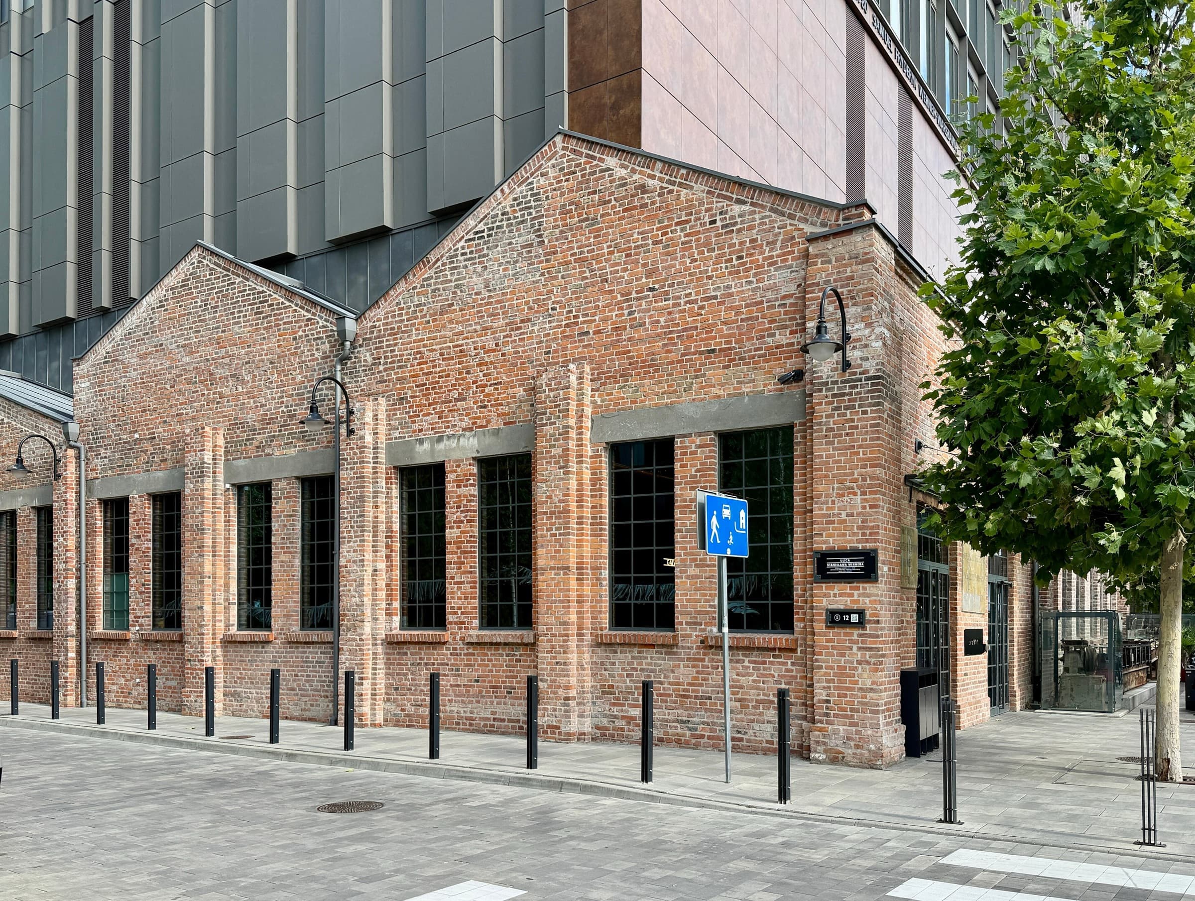 Restored red-brick factory halls with twin gables at Fabryka Norblina